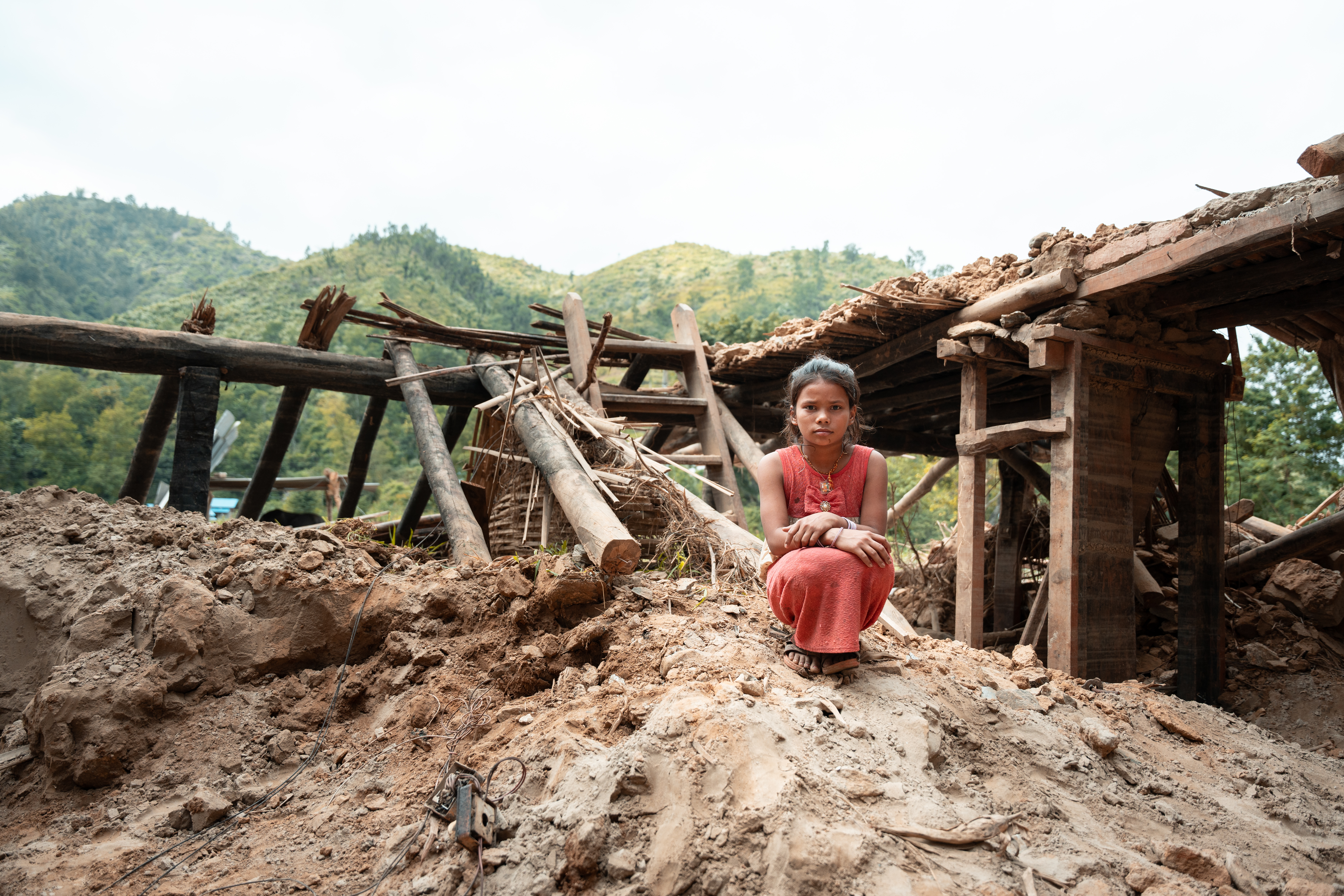 Geeta stands on the rubble of her former home after intense rains caused the Koshi River to overflow in Nepal.