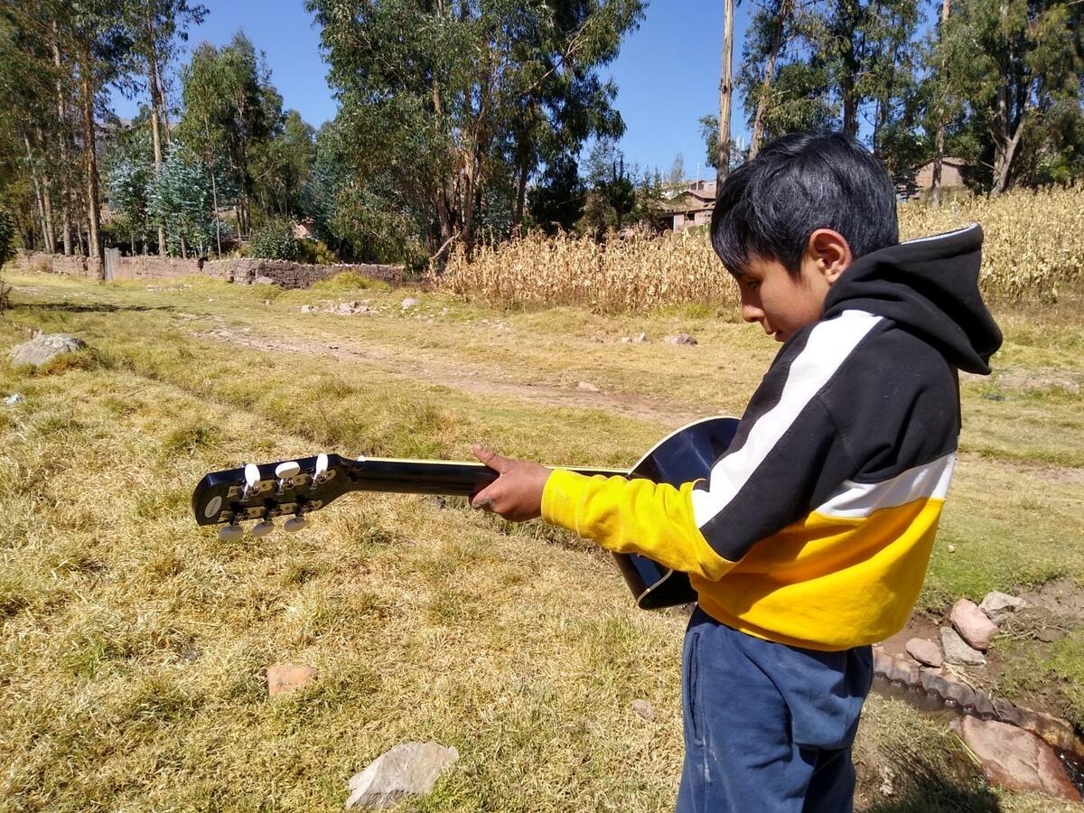 David in Peru loves playing on the guitar he received through World Vision.