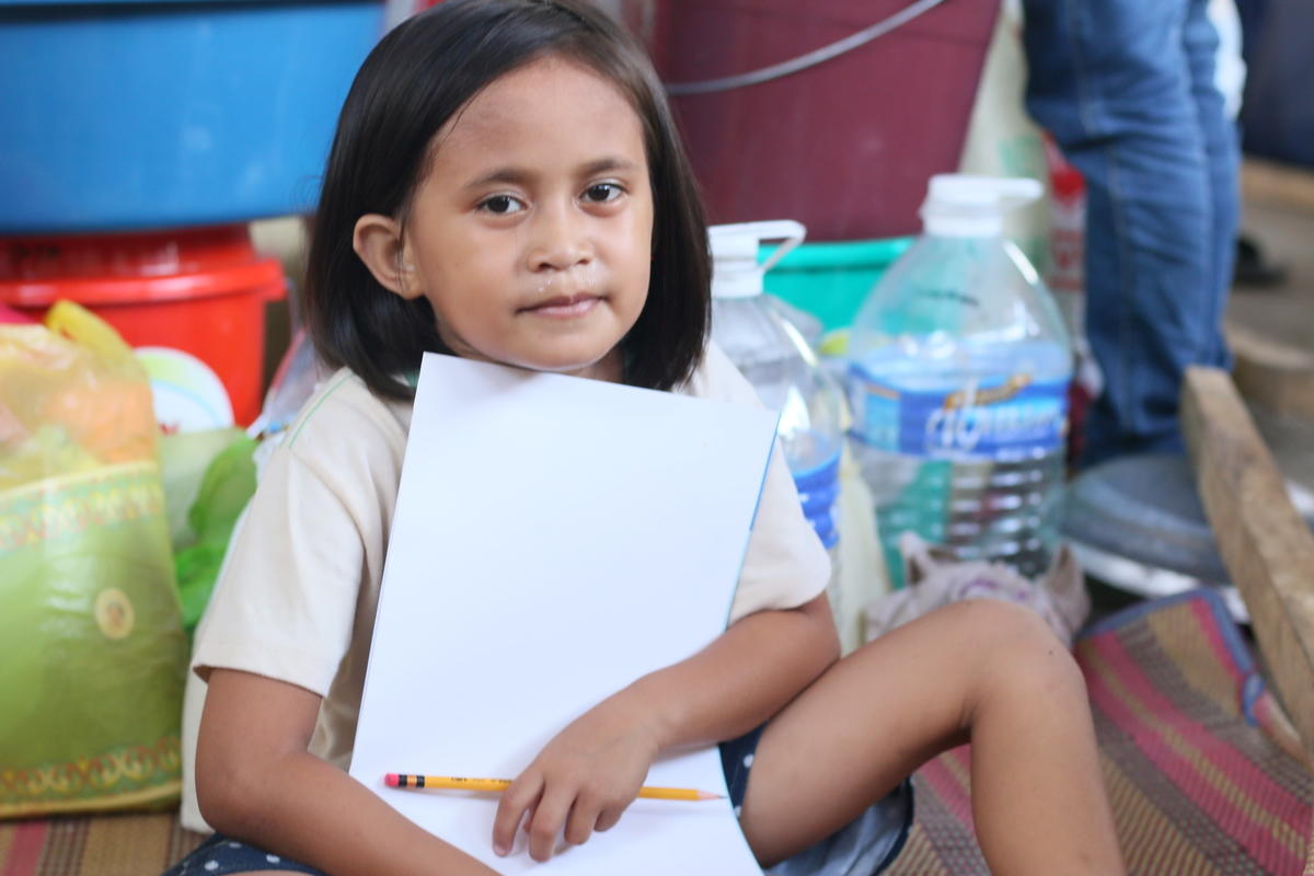 Young refugee girl shows her drawing