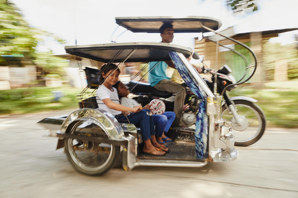 children riding a tuktuk
