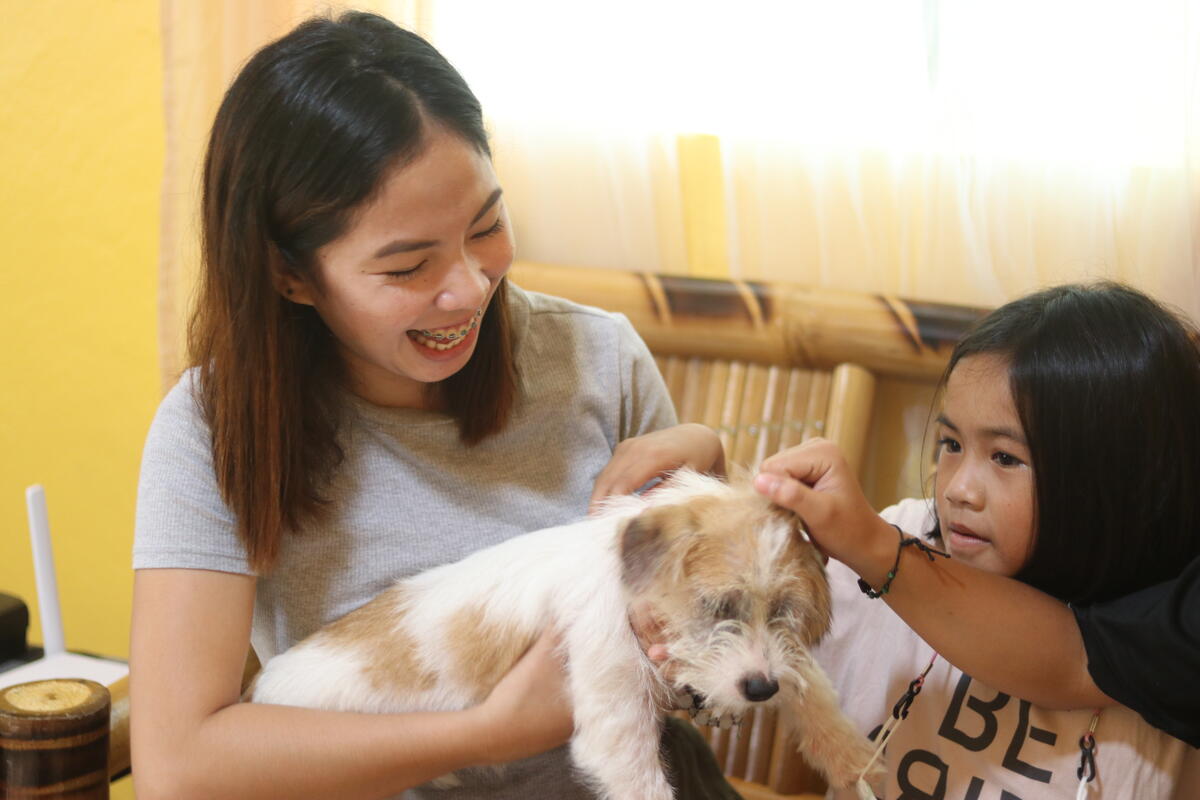 Lesly at home with her family and puppy.