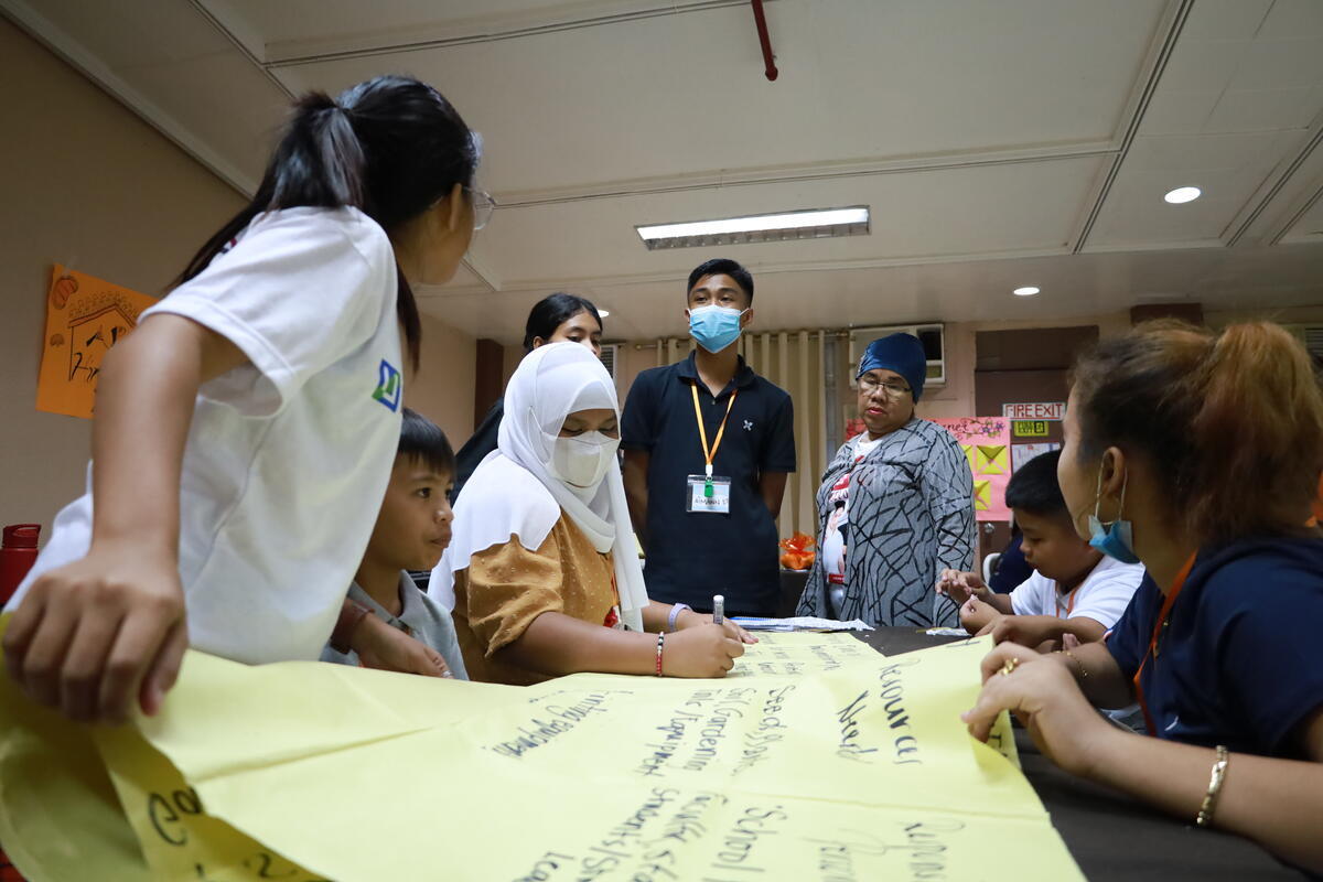 Dausa (white hijab) works with a group of children during the Children's congress