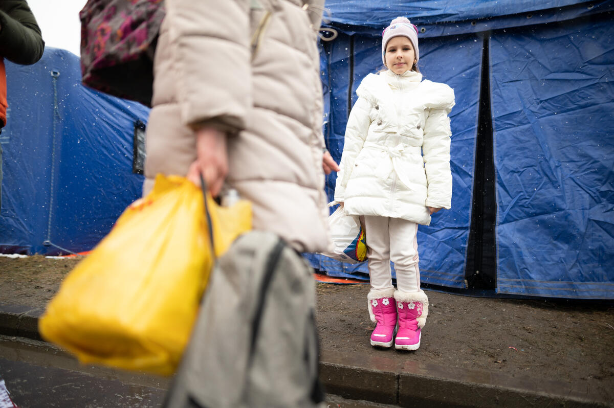 Ukrainian refugee girl with carrier bags in shot