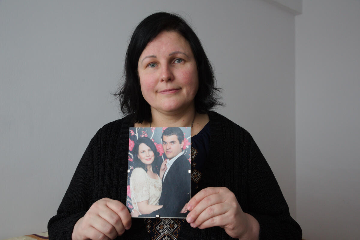 Julia holds the image of her with her husband Leonid.