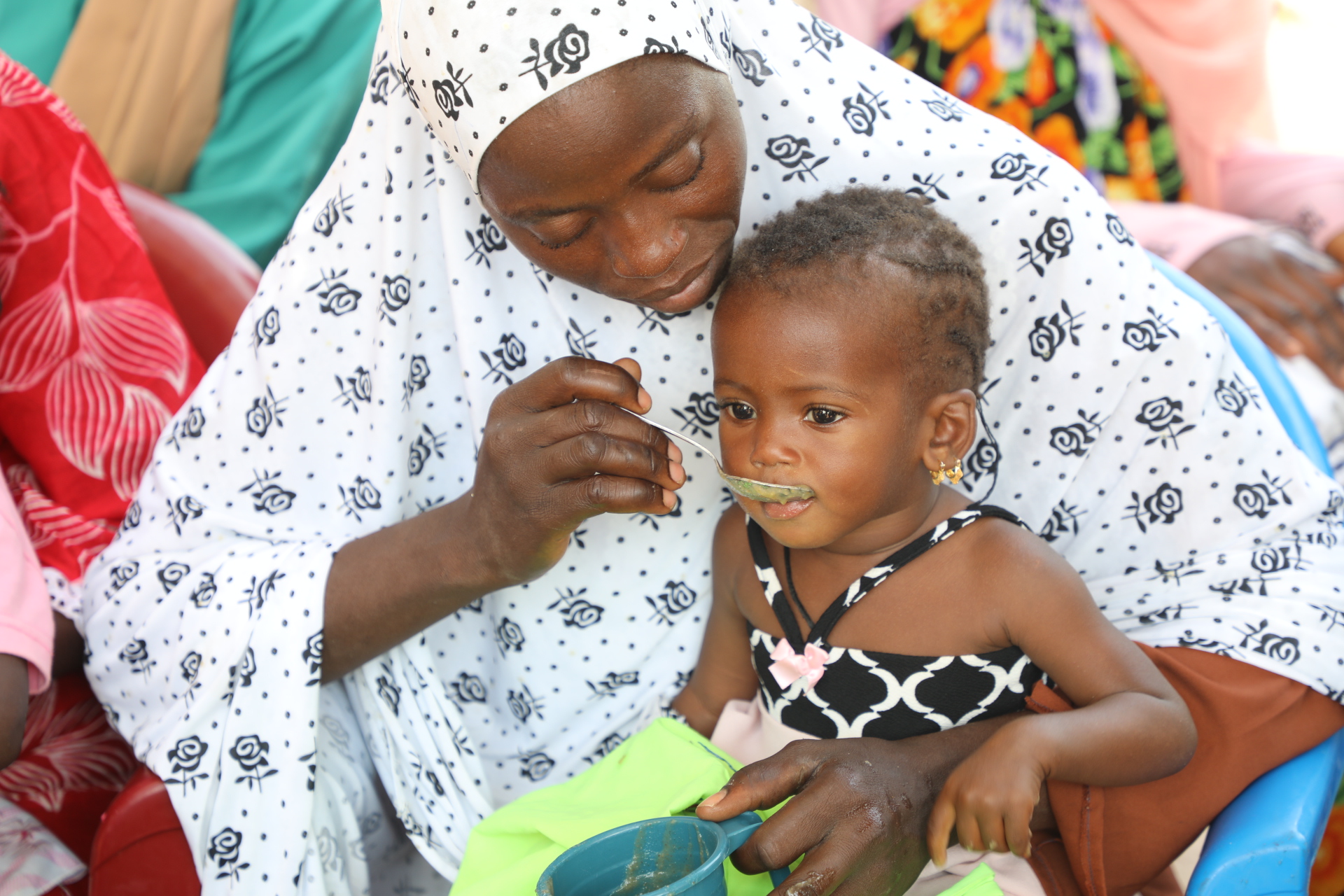 Alima’s mother feeds her a healthy meal after receiving support from community volunteers and a World Vision nutrition specialist in western Senegal.