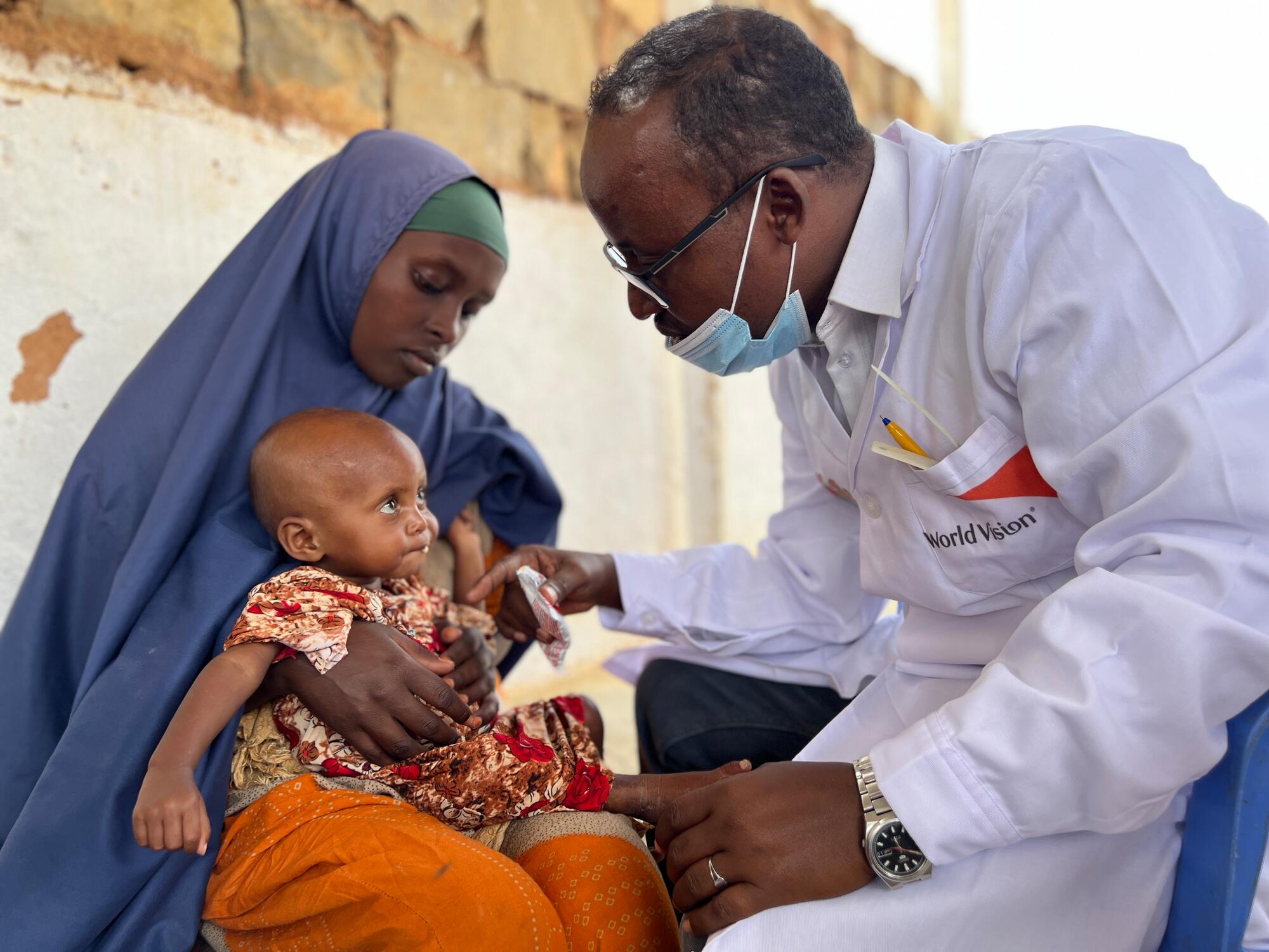 world vision staff looking over a child