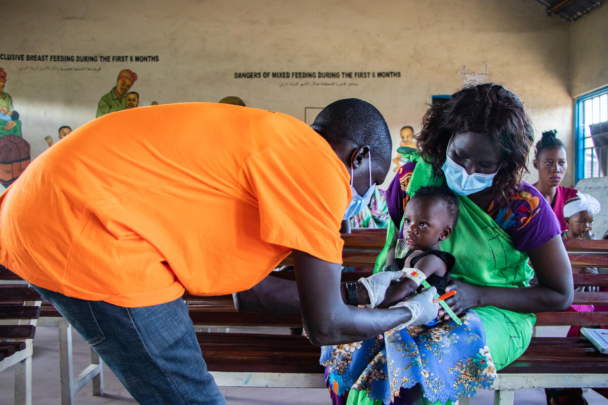 World Vision staff checks child for malnourishment