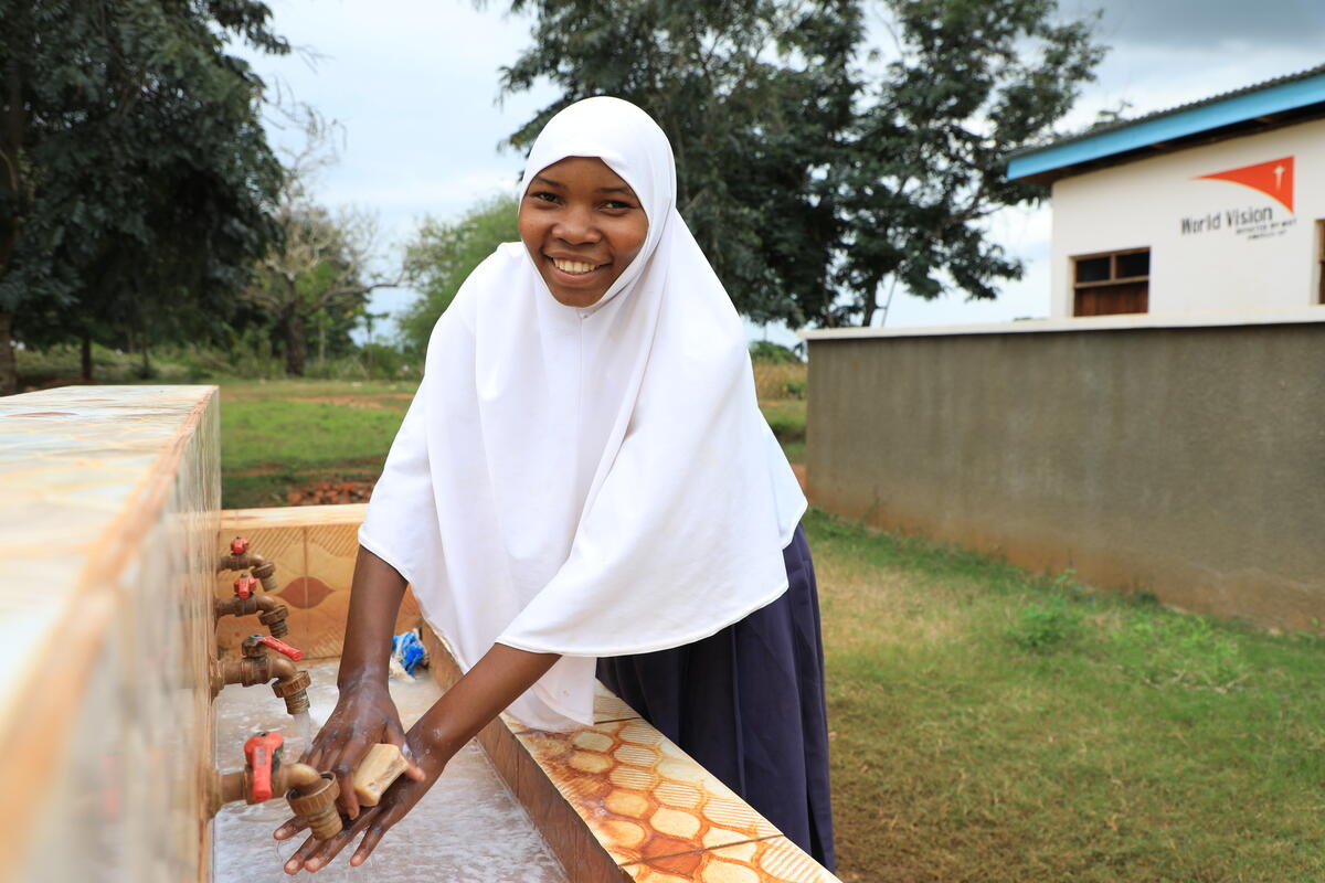 Girl washing her hands with piped water