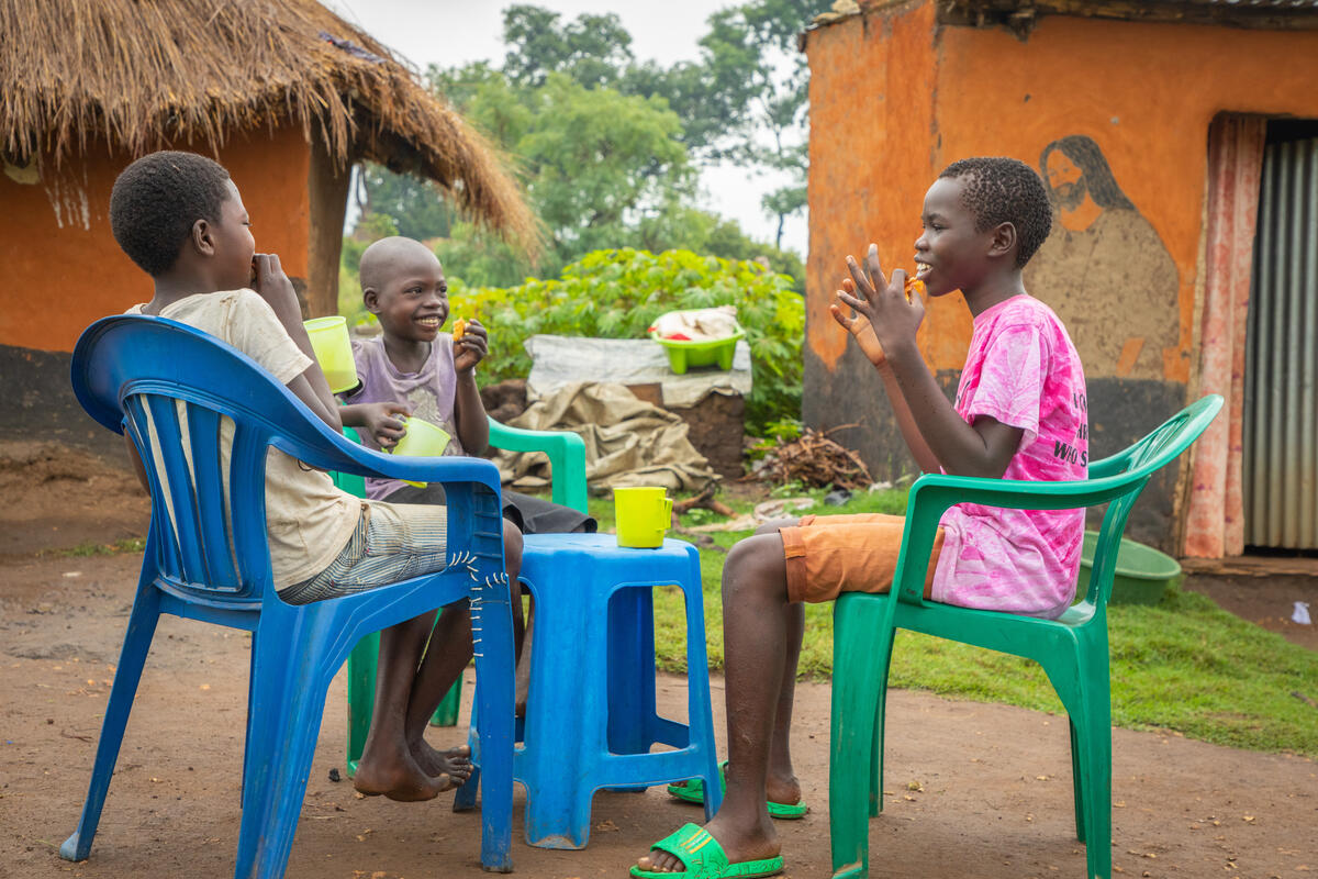 Angelo a refugee in Uganda eats with his family
