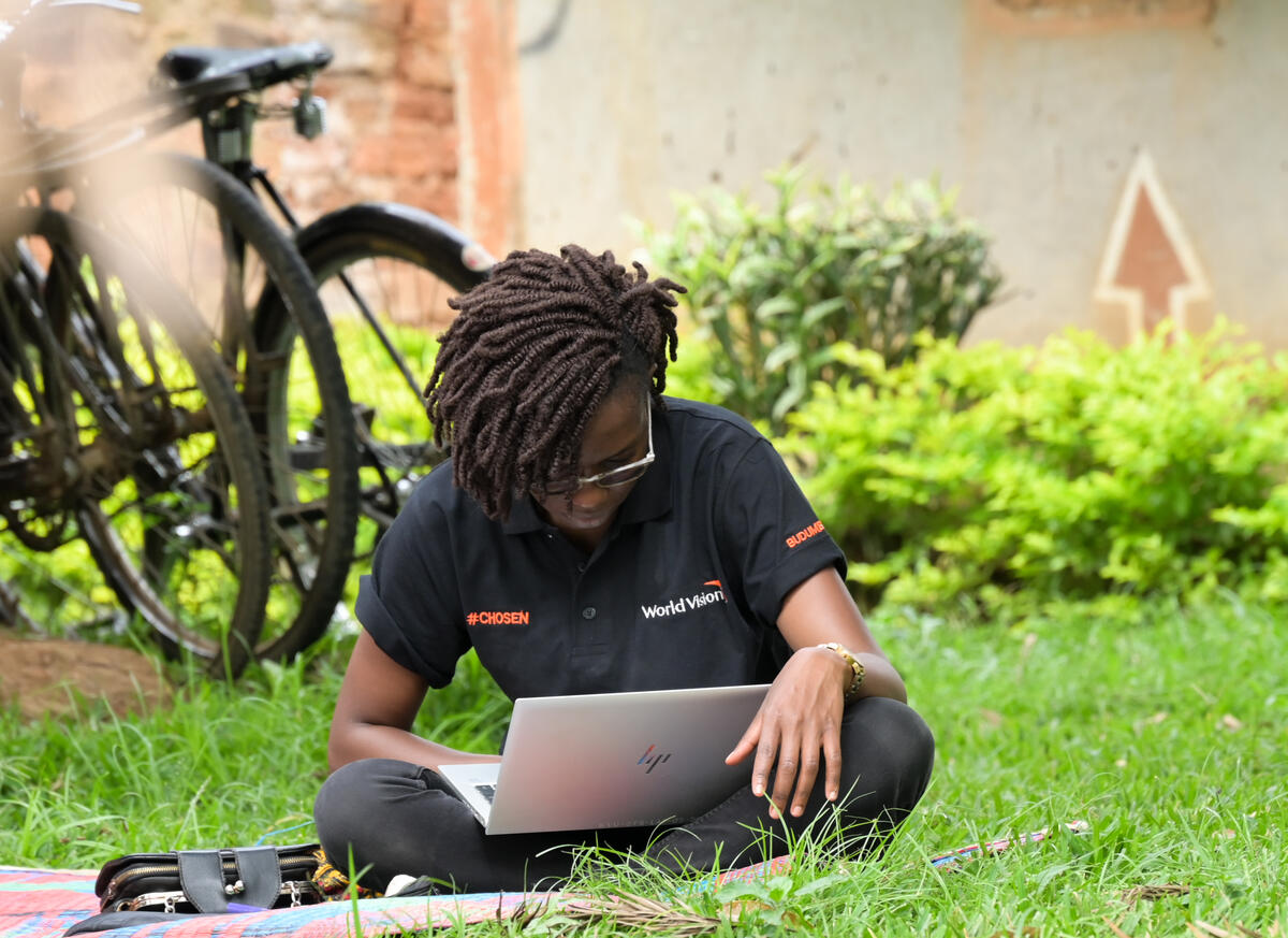World Vision staff with laptop on grass