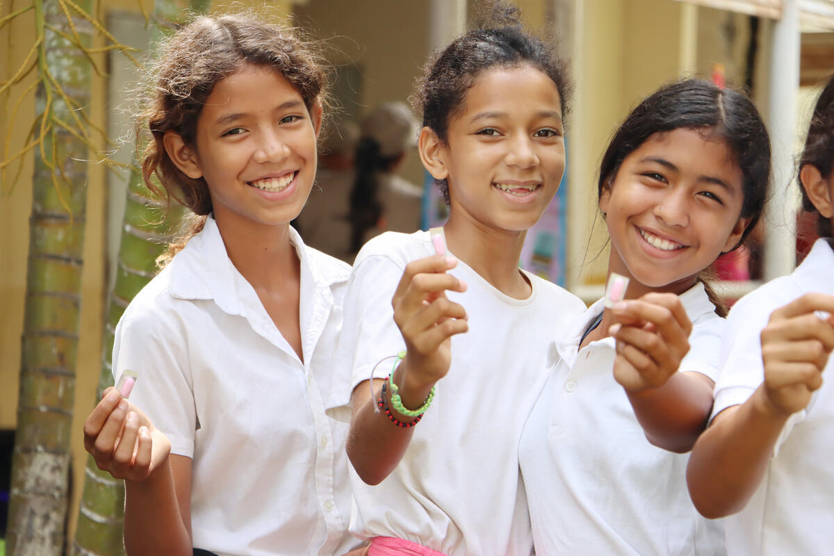 Three happy students with their strawberry flavored de-worming tablet.