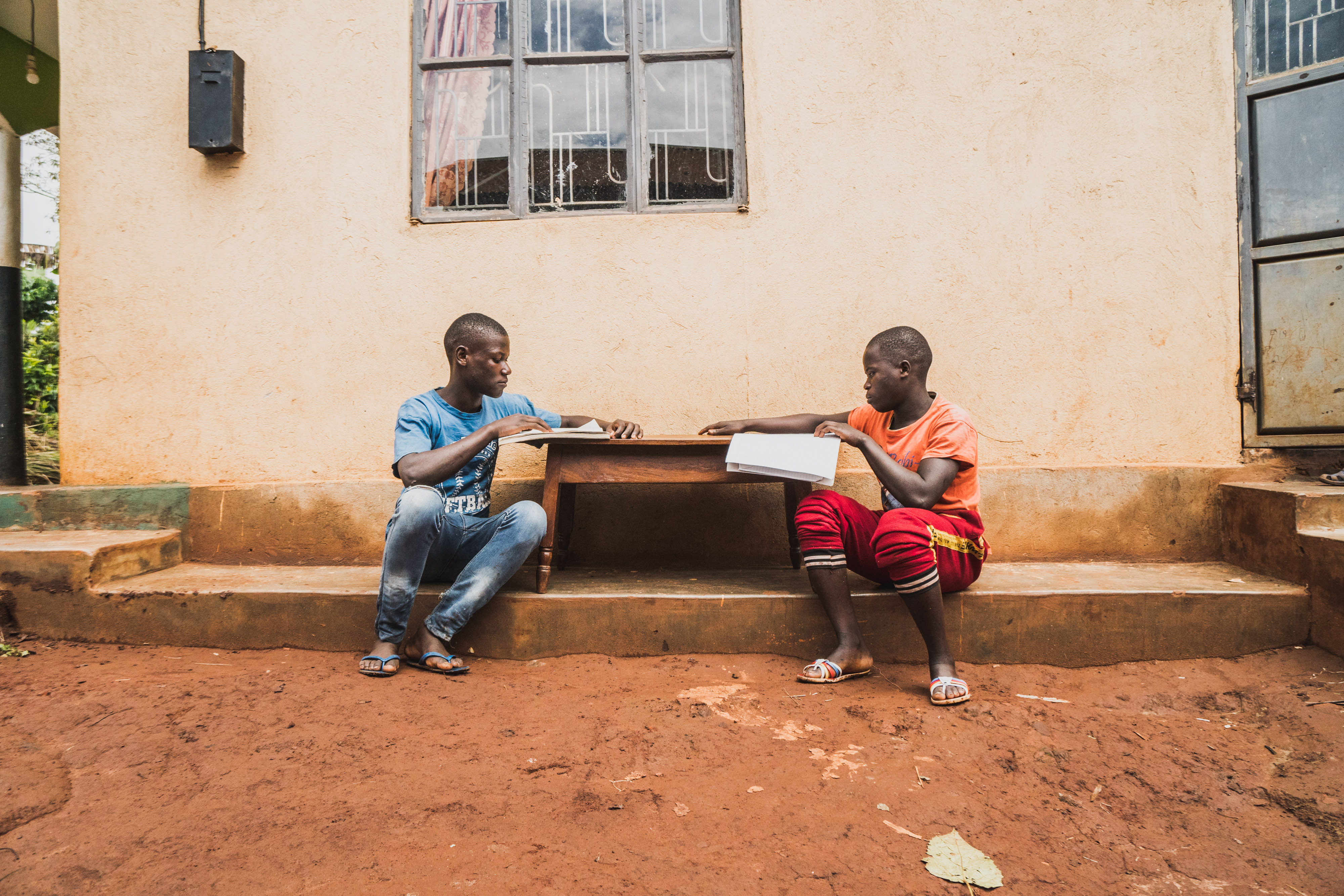 Christoph and Peter pull out their schoolbooks to study. 