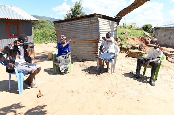 Stella (left) – a community health volunteer supported by World Vision – teaching families how cough with flexed elbows so as to avert the spread of COVID-19 at her village in Bartabwa,Baringo County, Kenya.
