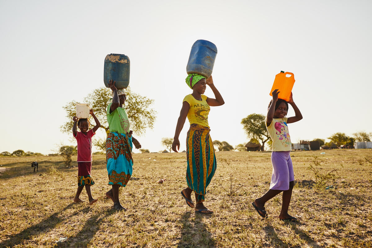 Children carry clean water home from their schools in Mozambique