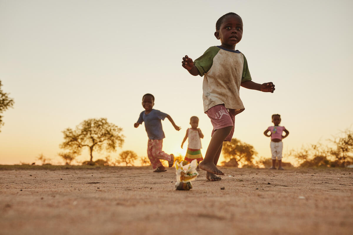 Children running across open ground in Mozambique