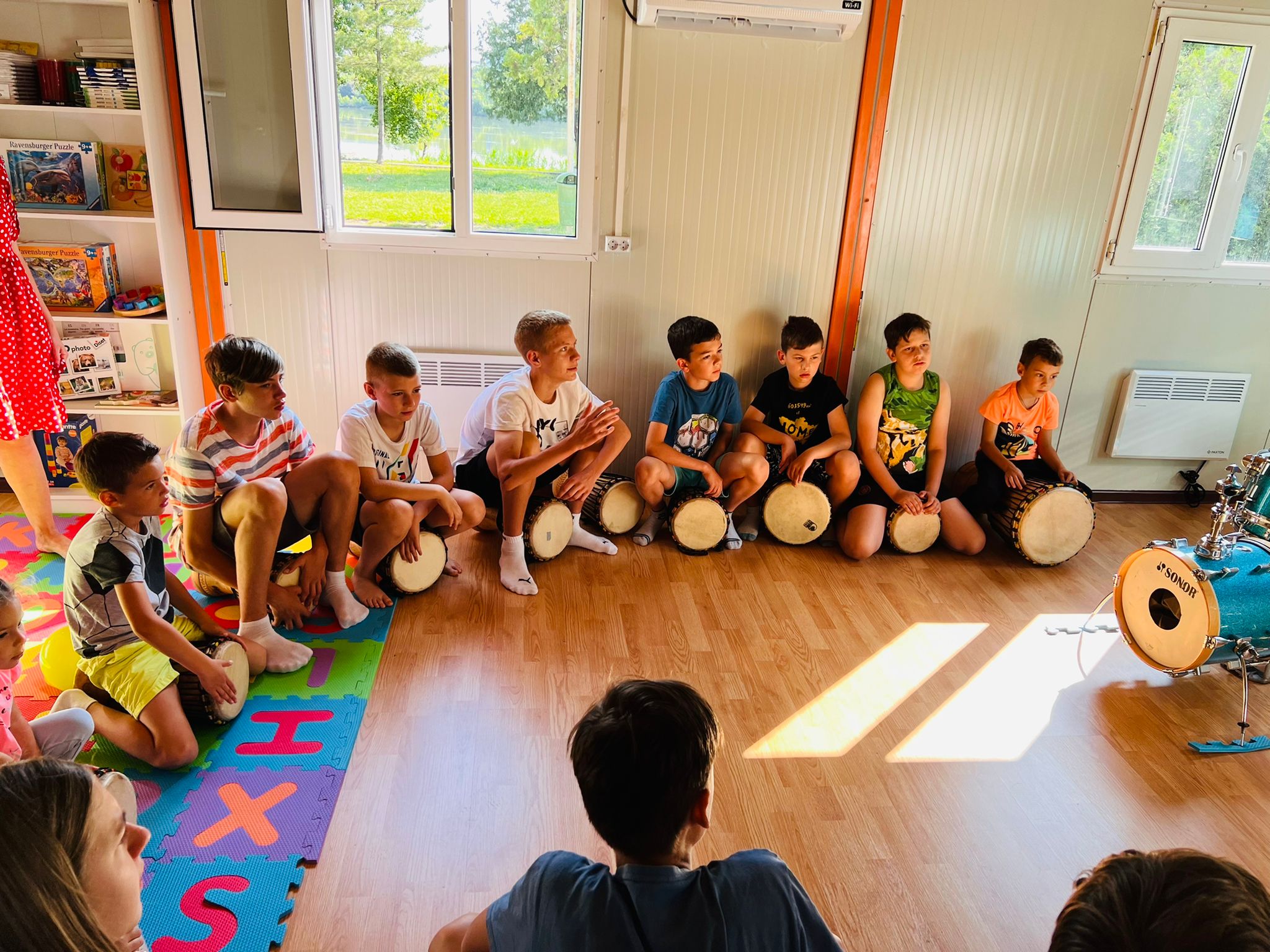 Children sit with footballs in the Happy Bubble