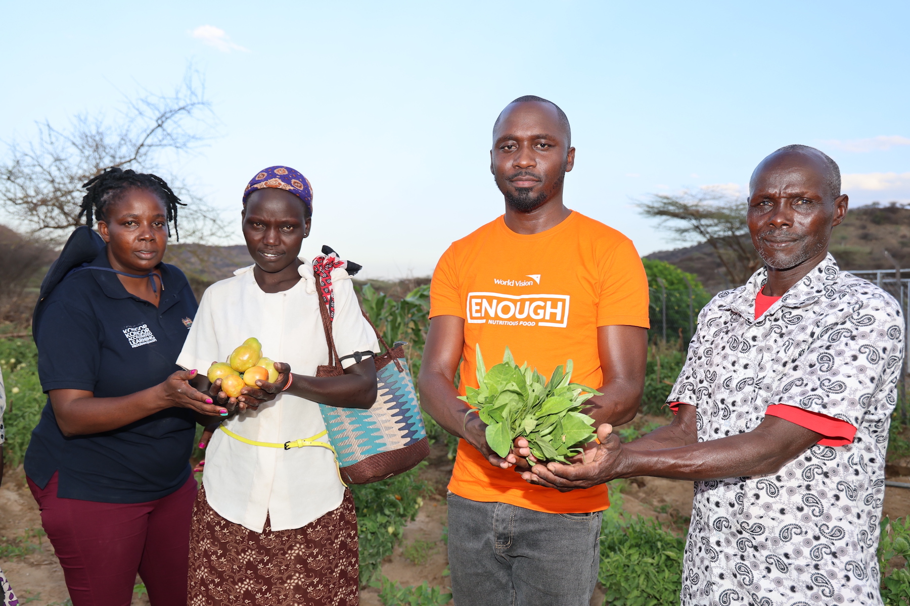 World Vision staff with Lorus and his wife showing some of the produce from the farm that has improved food security in the region. 
