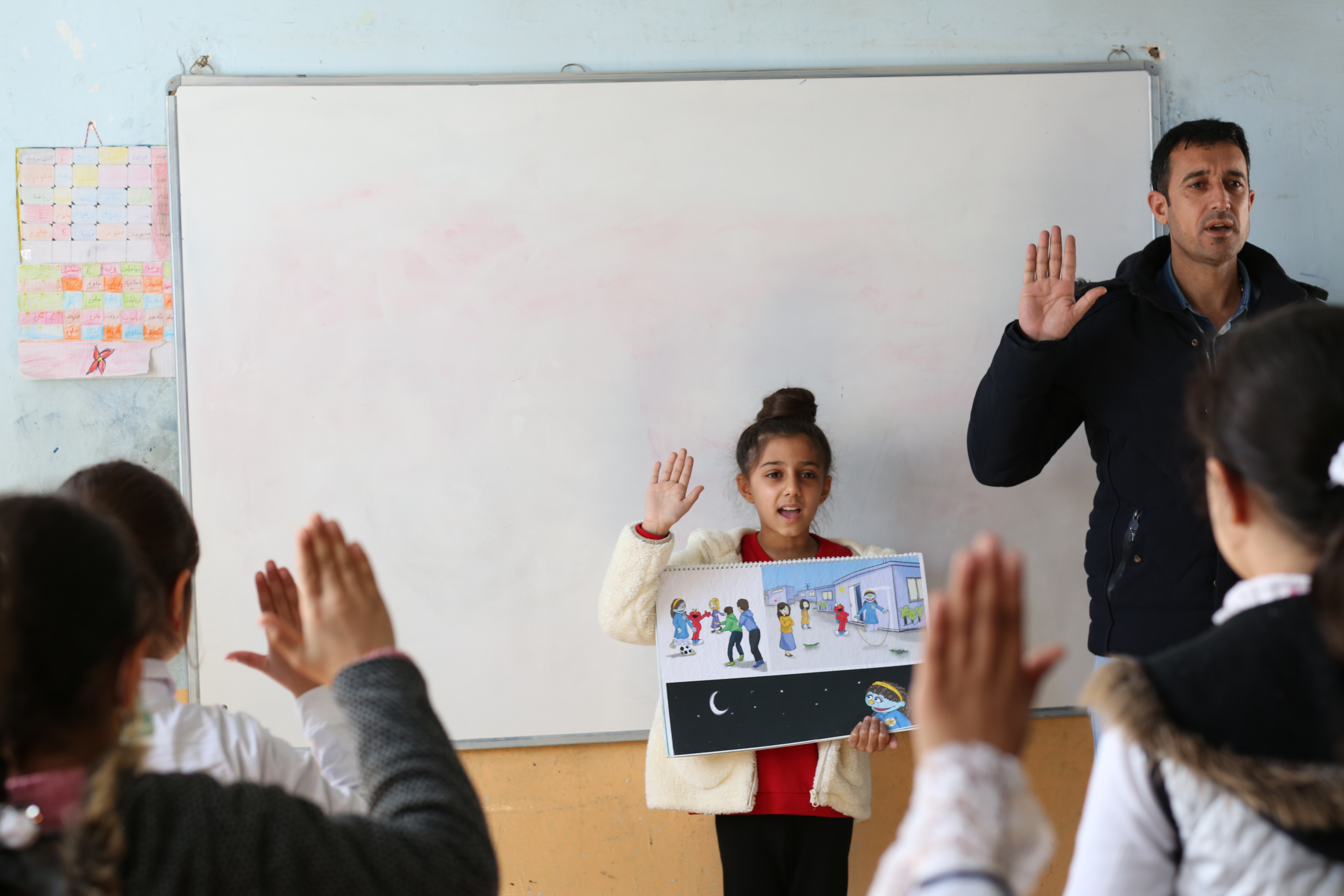 Zahraa reads the story book in school