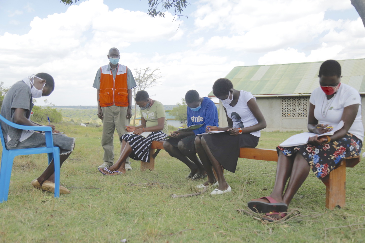 Zipporah, 15, with her friends studying together. During such forums, she takes the opportunity to empower them to know their rights and shun FGM and child marriage in Narok County, Kenya. In the background is Julius Kedoki, the Education & Child Protection officer for World Vision in Narok, Kenya.