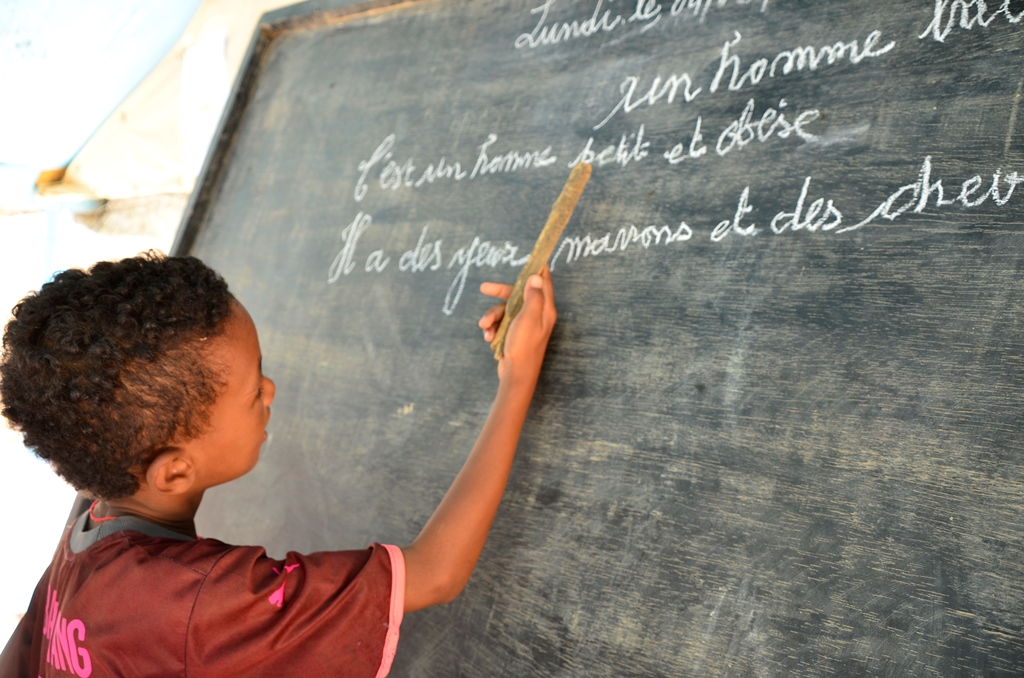 child writing on a chalkboard 