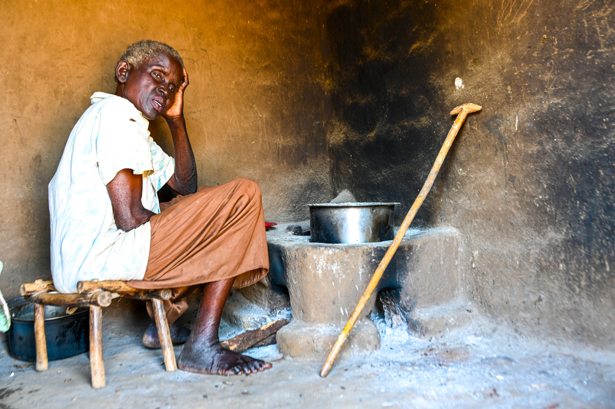 Nensa's grandmother Joyce sitting next to an empty saucepan placed on a cold stove
