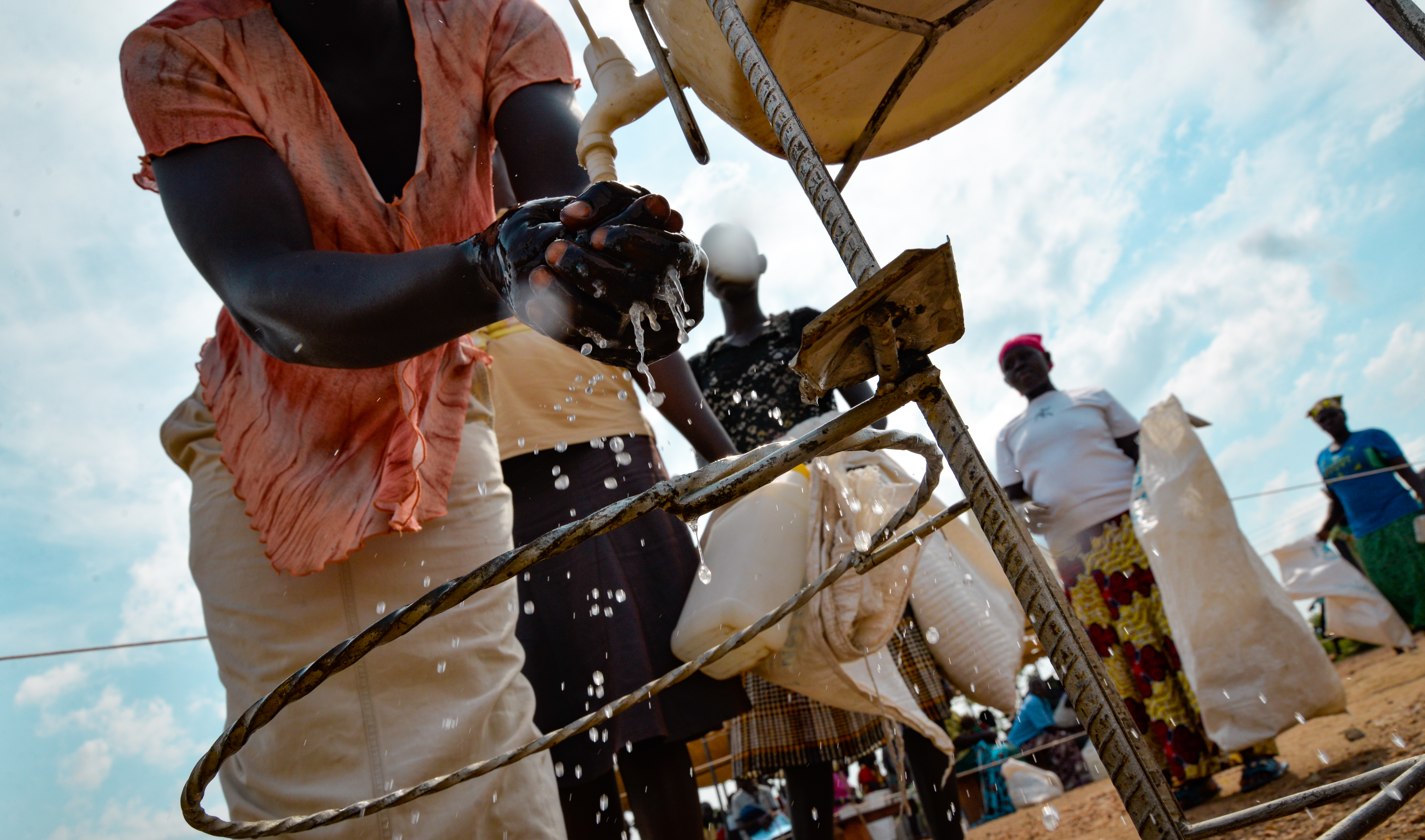 Women washing their hands before receiving food in Bidibidi 