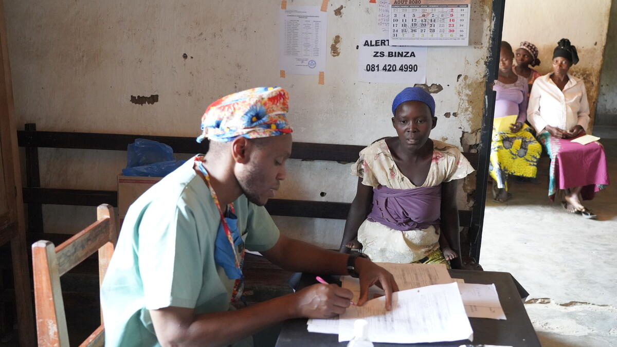 Senior nurse documents progress of a mother’s child recovering from malnutrition