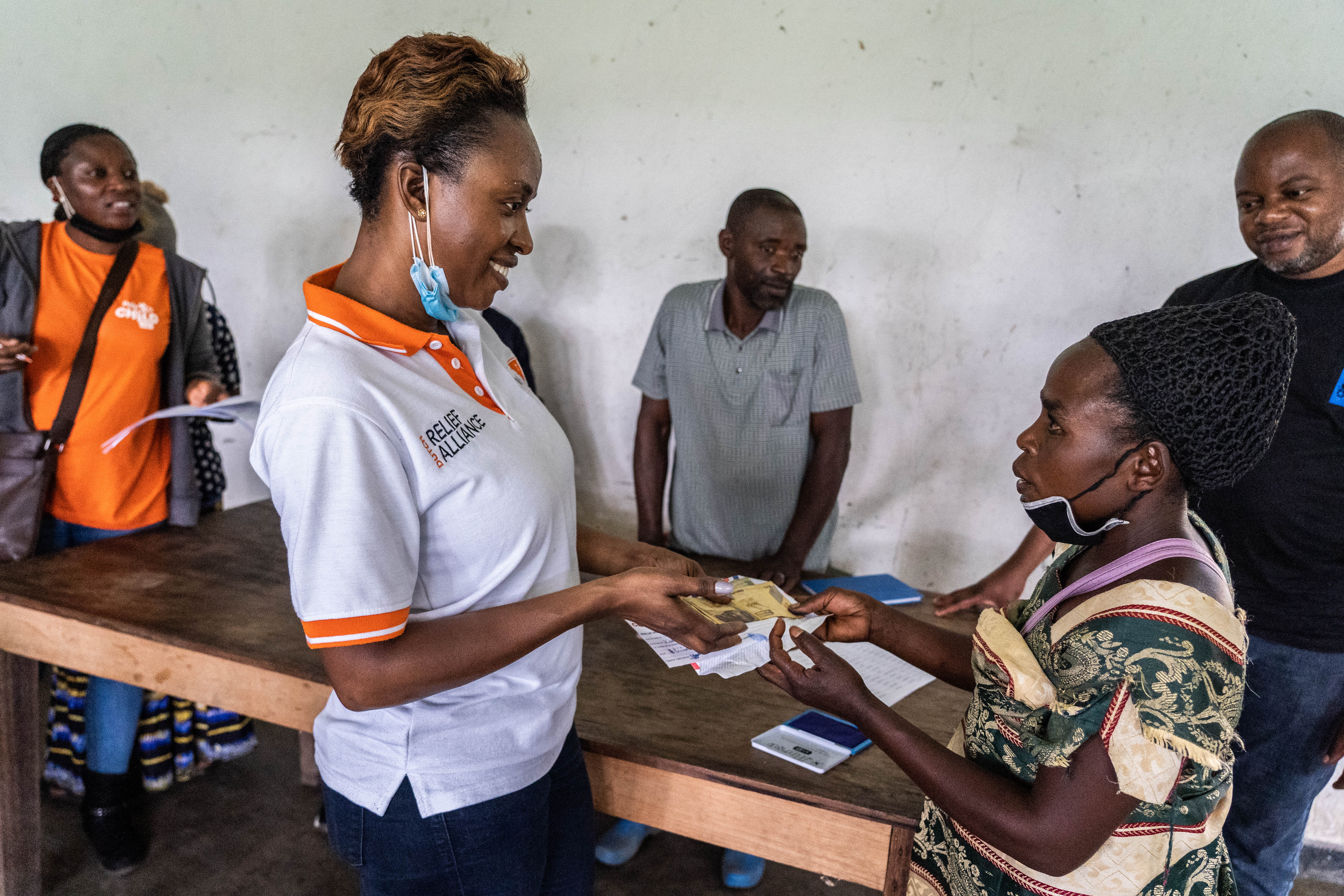 Stephania distributing cash to a beneficiary