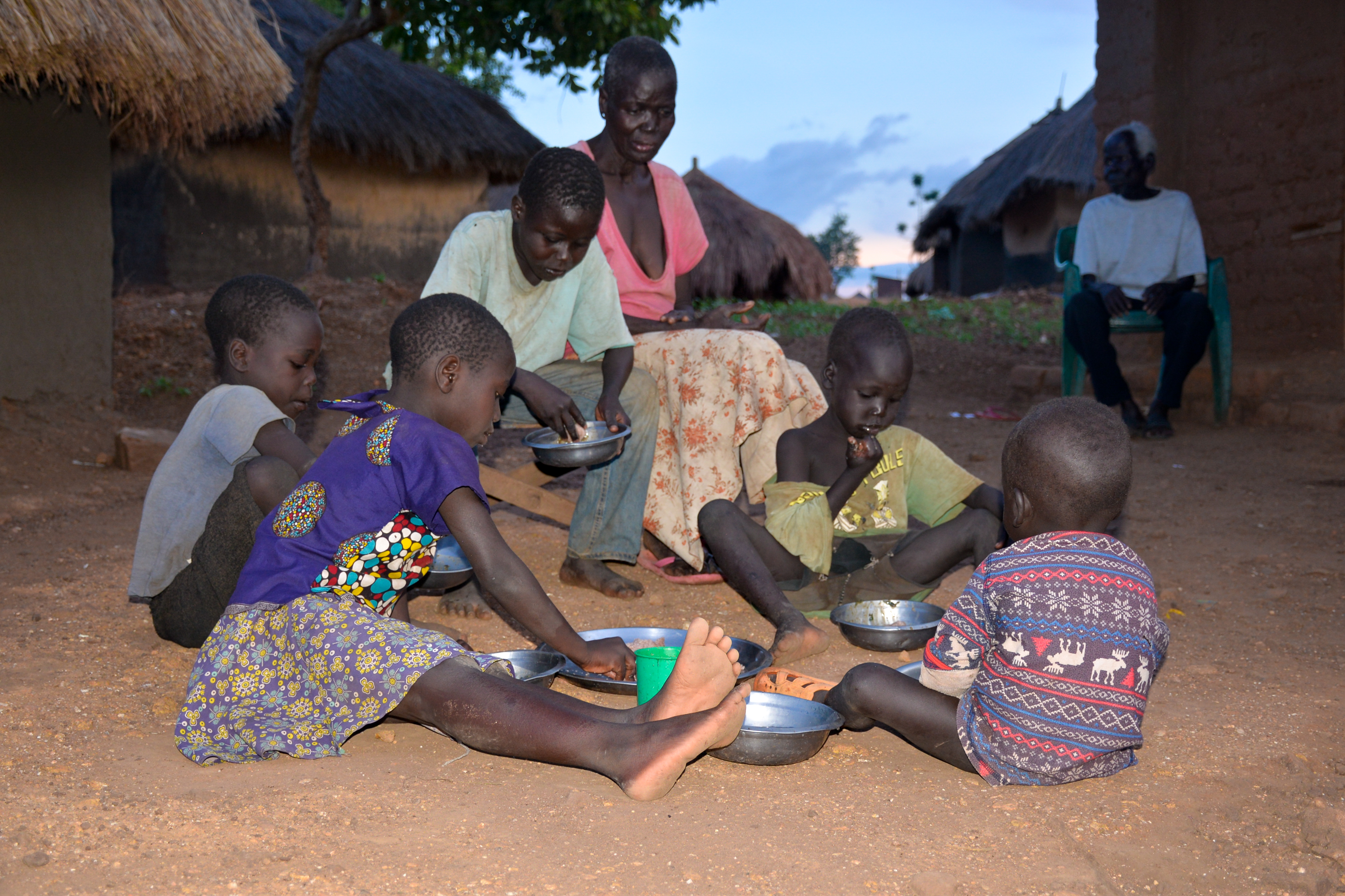 As the children eat, the elders just look on because the food isn’t enough for everyone 