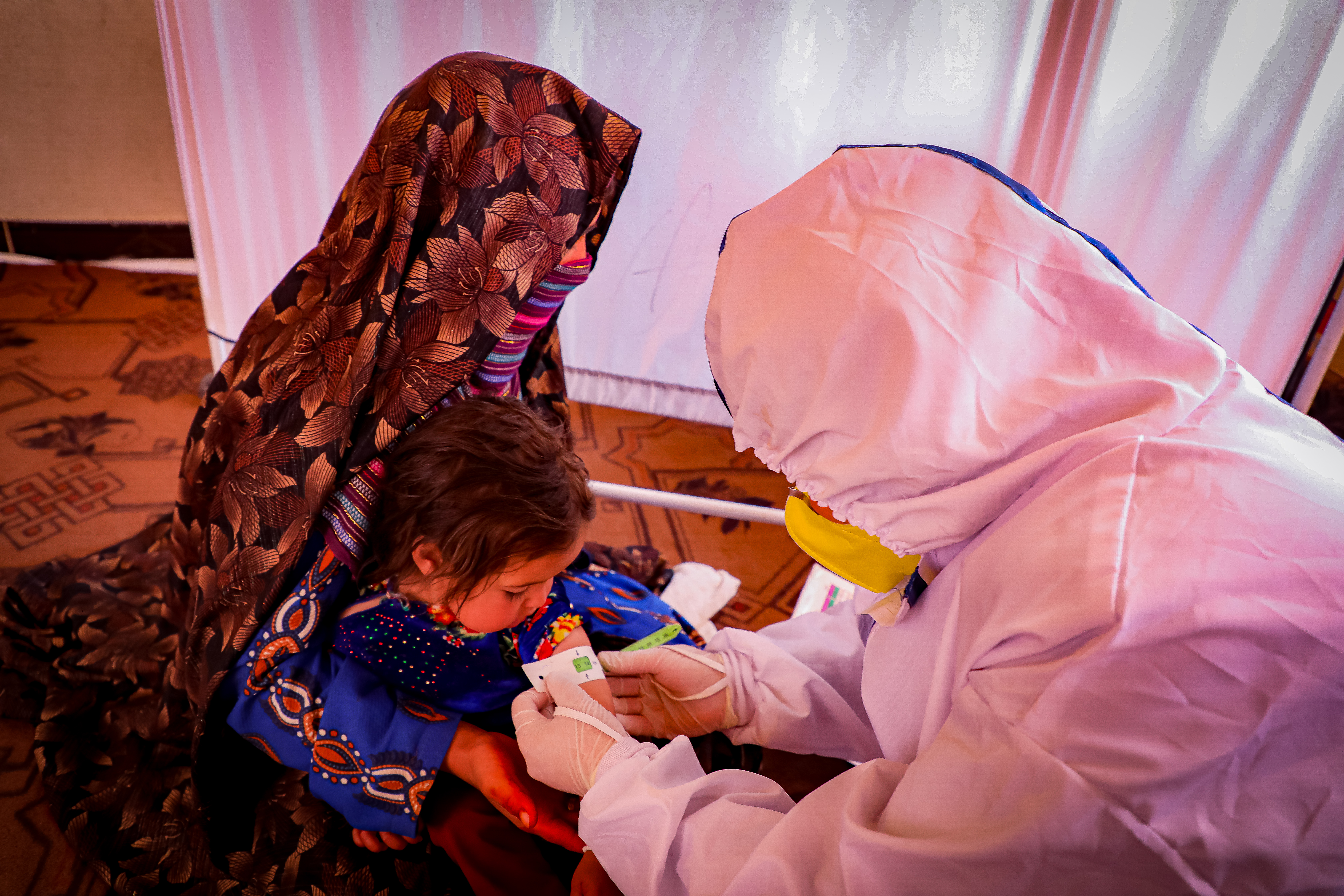 Nutrition nurse is checking Guldasta's daughter. 