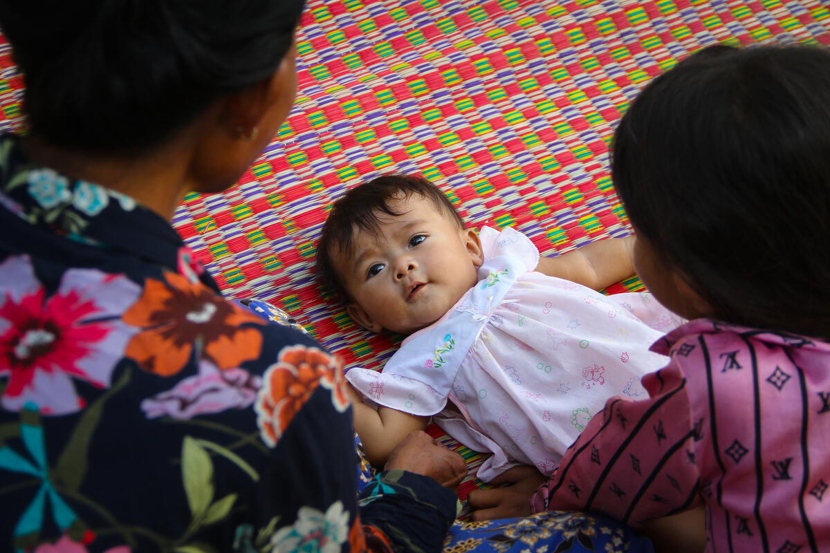 A baby looks lovingly at her grandmother in Cambodia.