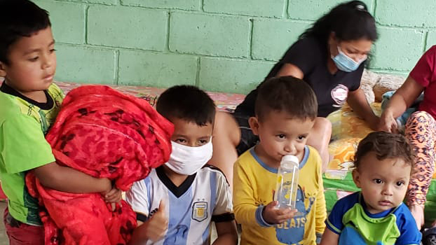 Francisca's grandchildren look through the emergency kits at their shelter