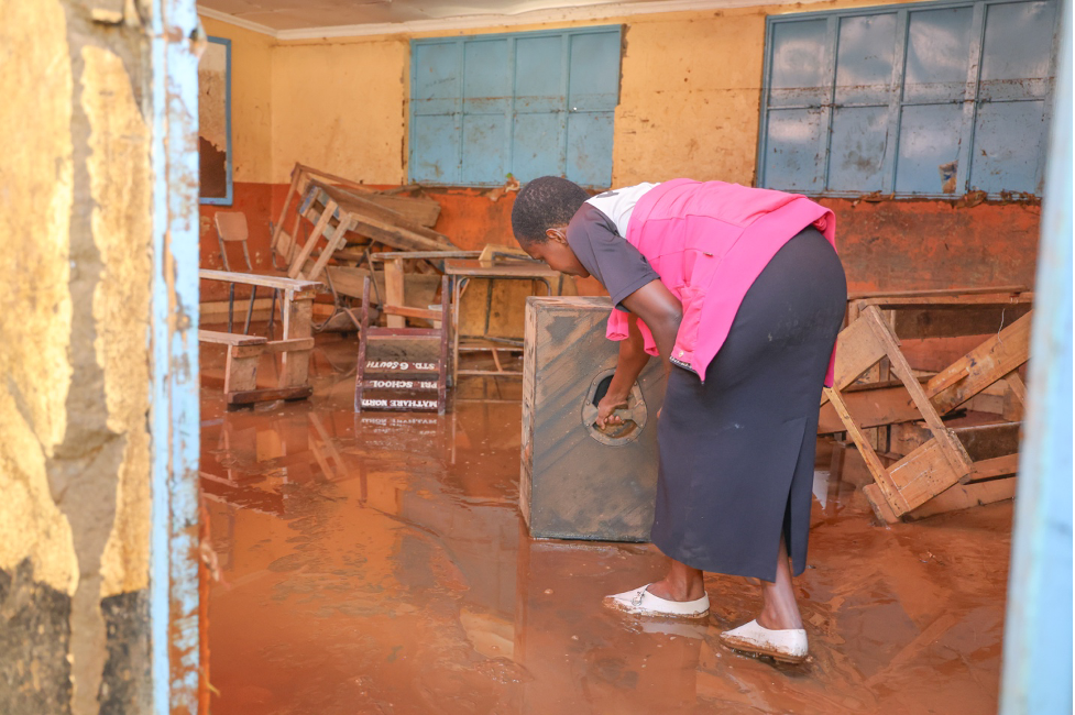 A parent from Mathare North Primary School is seen rescuing equipment following heavy floods that have destroyed valuables of unknown value.