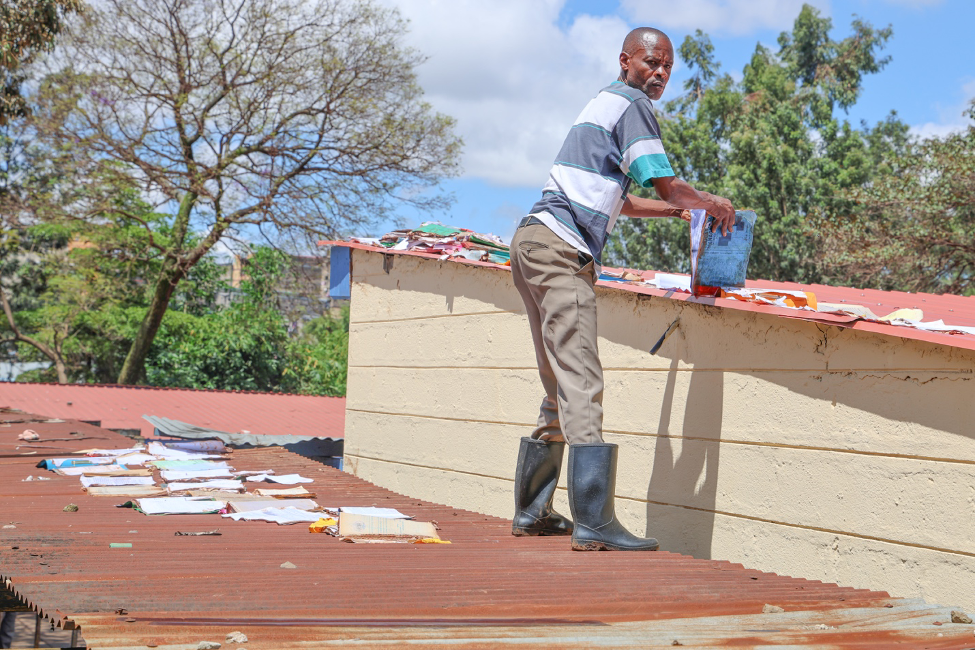 With the floods affecting learning materials for children in Mathare, volunteers try to dry the books on top of the roof of Mathare North Primary School in Nairobi