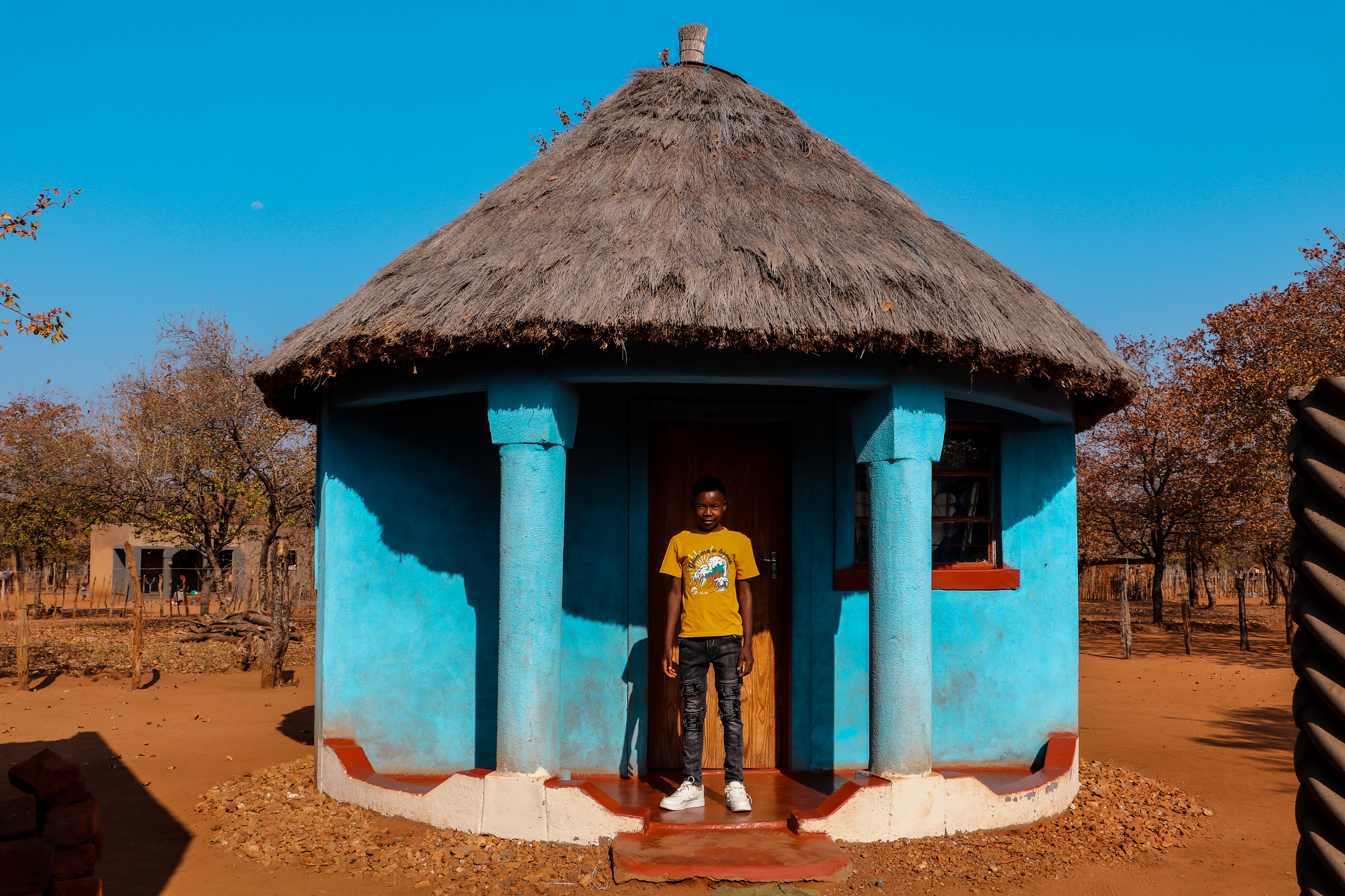 With a smile of pride, Sydney stands before the bedroom he was able to build with support from the GNs from his sponsor.