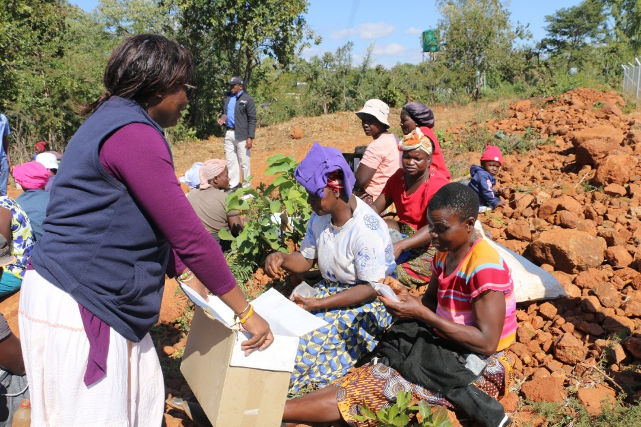 Makaita, a World Vision Zimbabwe staff member distributes menstrual cups to women who attended the training