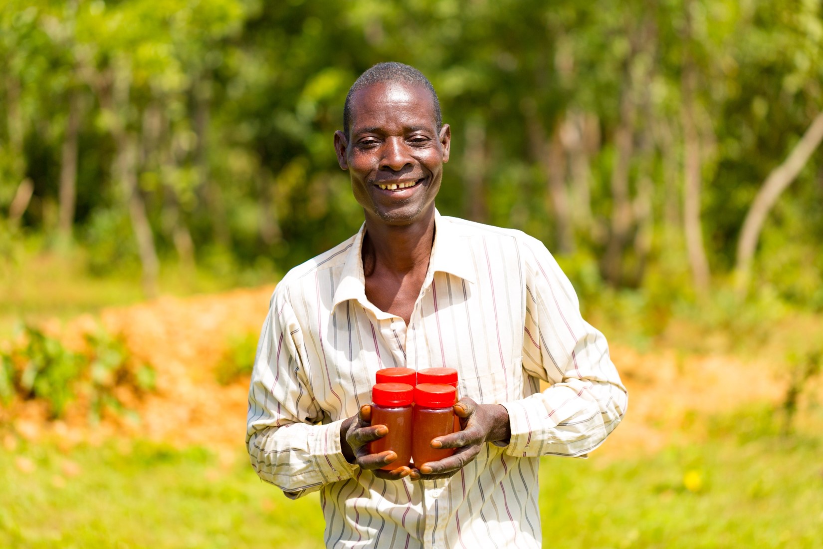 Alex Steven, Chairperson for Mankhwala Forest Beekeeping Club holding a bottle of their products.