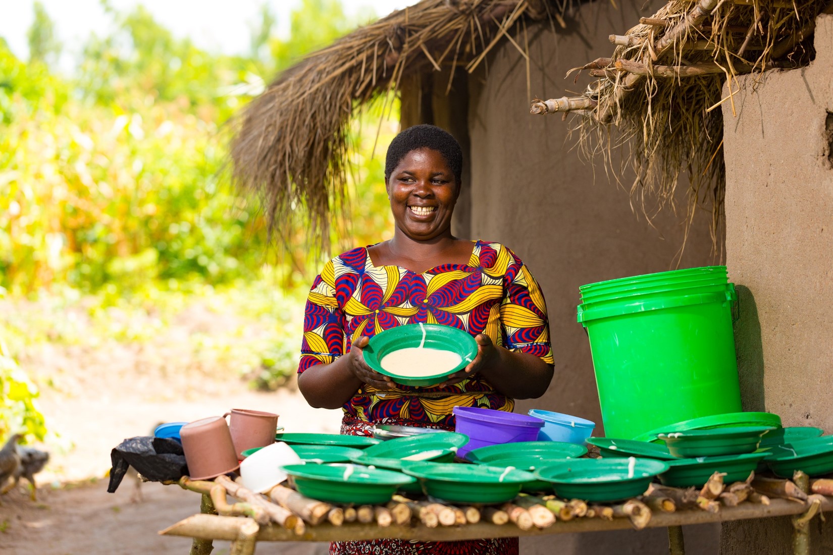 Eliza, a care giver at Tilimbike CBCC holding a plate of school meal.