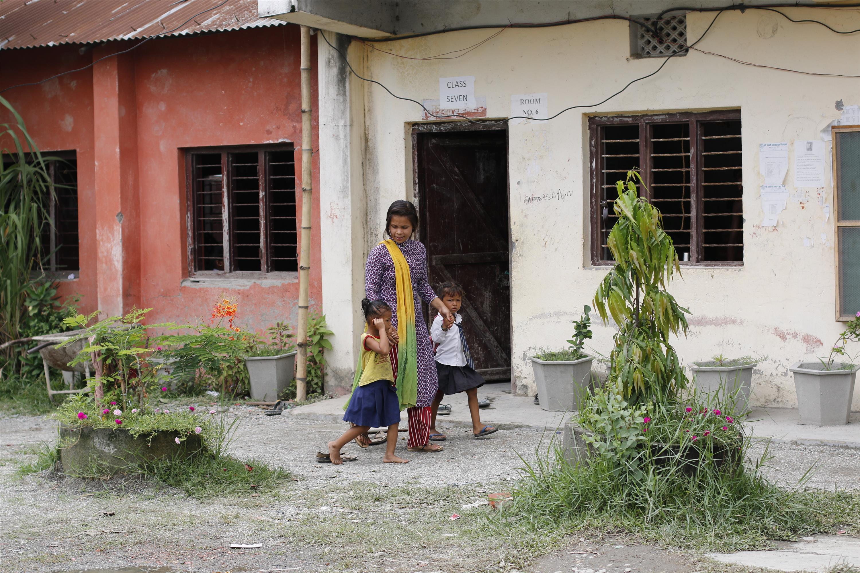 Prabha guides the two children to their classes 