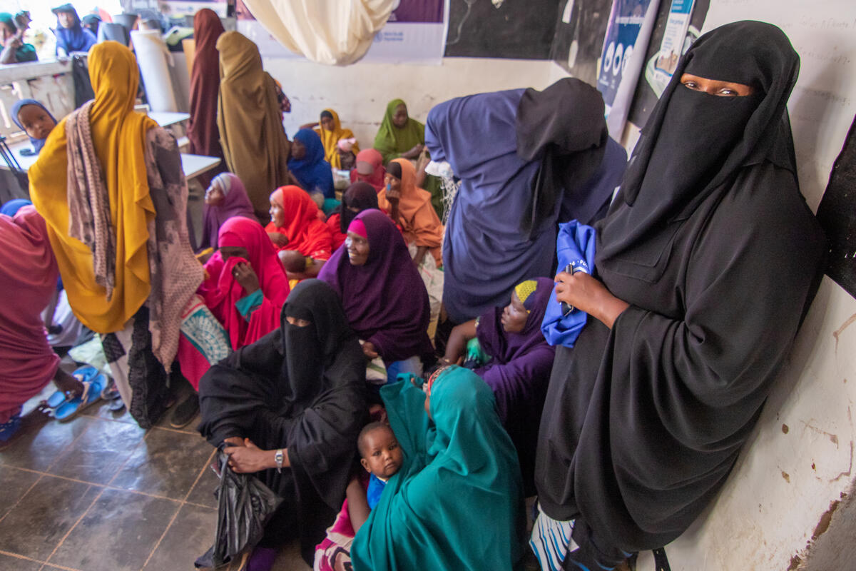 World Vision food distribution center in Shaafici Beneficiary receiving packets of special supplementary food to boost the nutrition for themselves and their children.