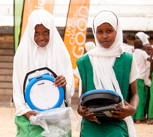 Zainab and her friend Kule display the solar lanterns that they received from World Vision and Suntransfer. ©World Vision Photo/Wesley Koskei.