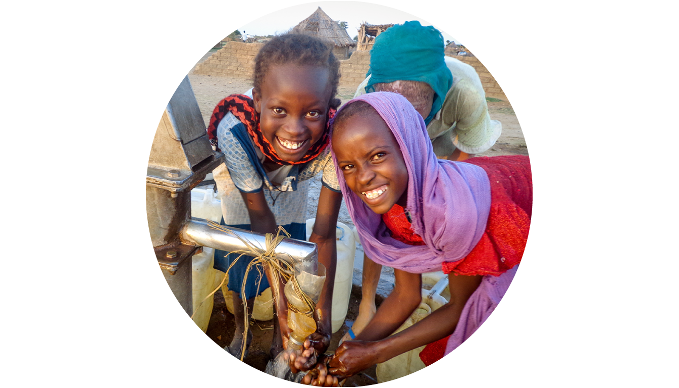 <alt="Two girls getting clean water">