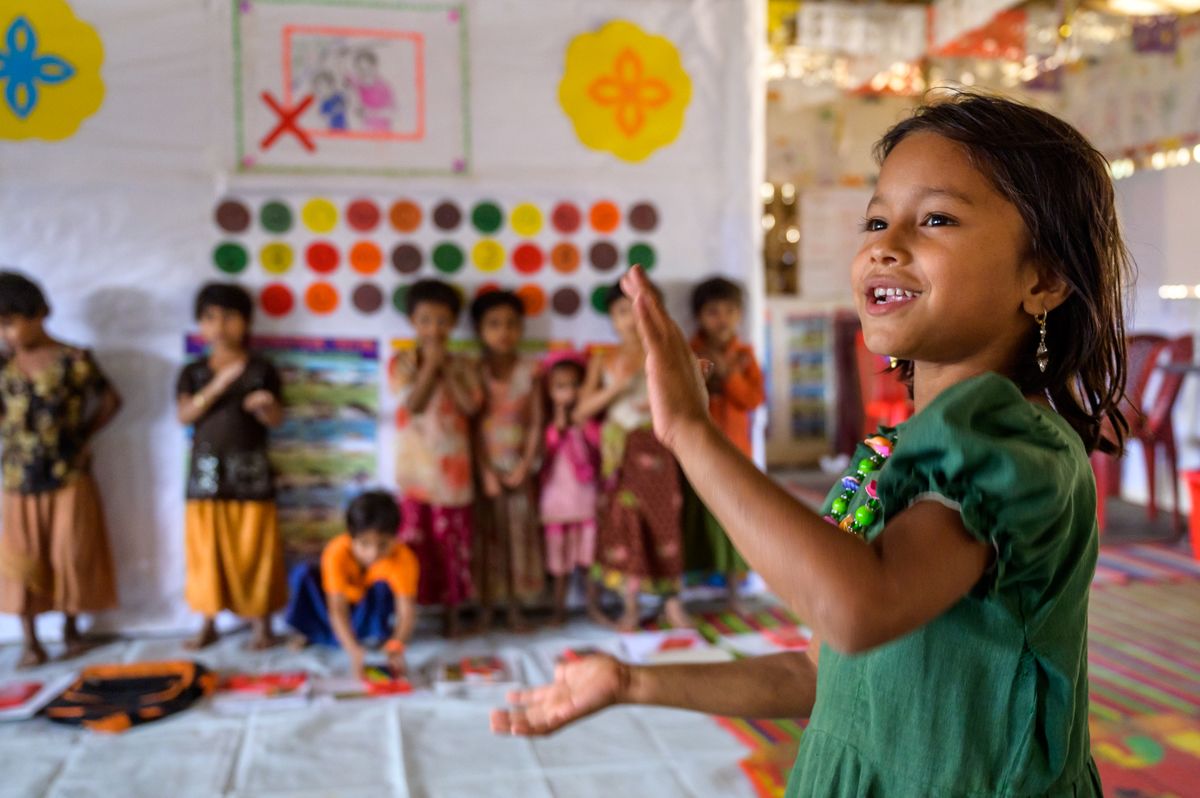 Girl playing with other children in child friendly space Bangladesh