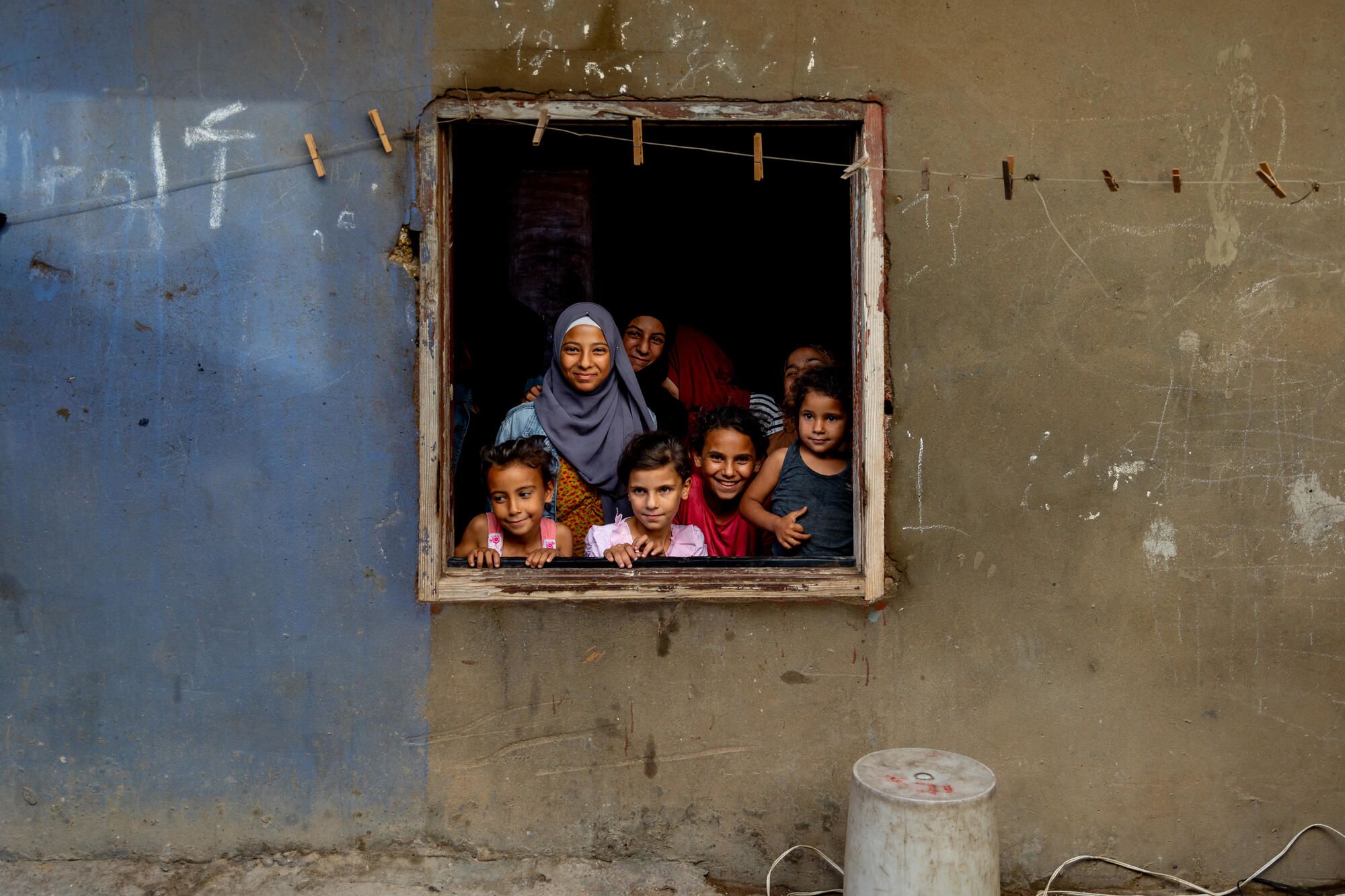 Several girls pose from inside an open window