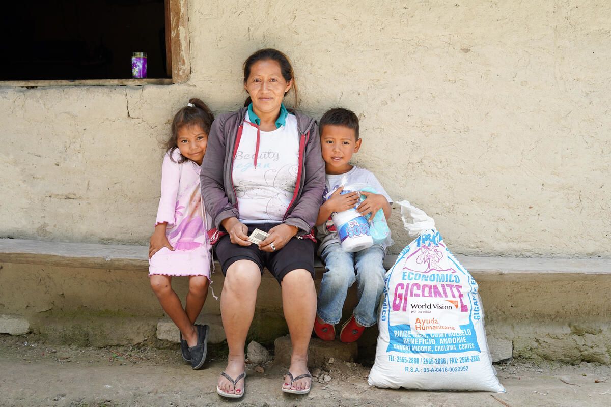 family in Hondras sits with food support provided by World Vision