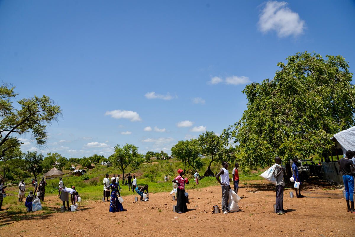 Parents stand in line at food distribution site in Uganda