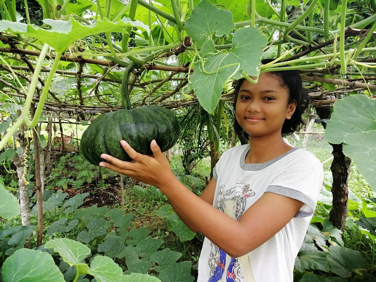 Karie, sponsored child from Philippines shows off produce from their family garden that has helped provide food, even during the global COVID-19 Pandemic