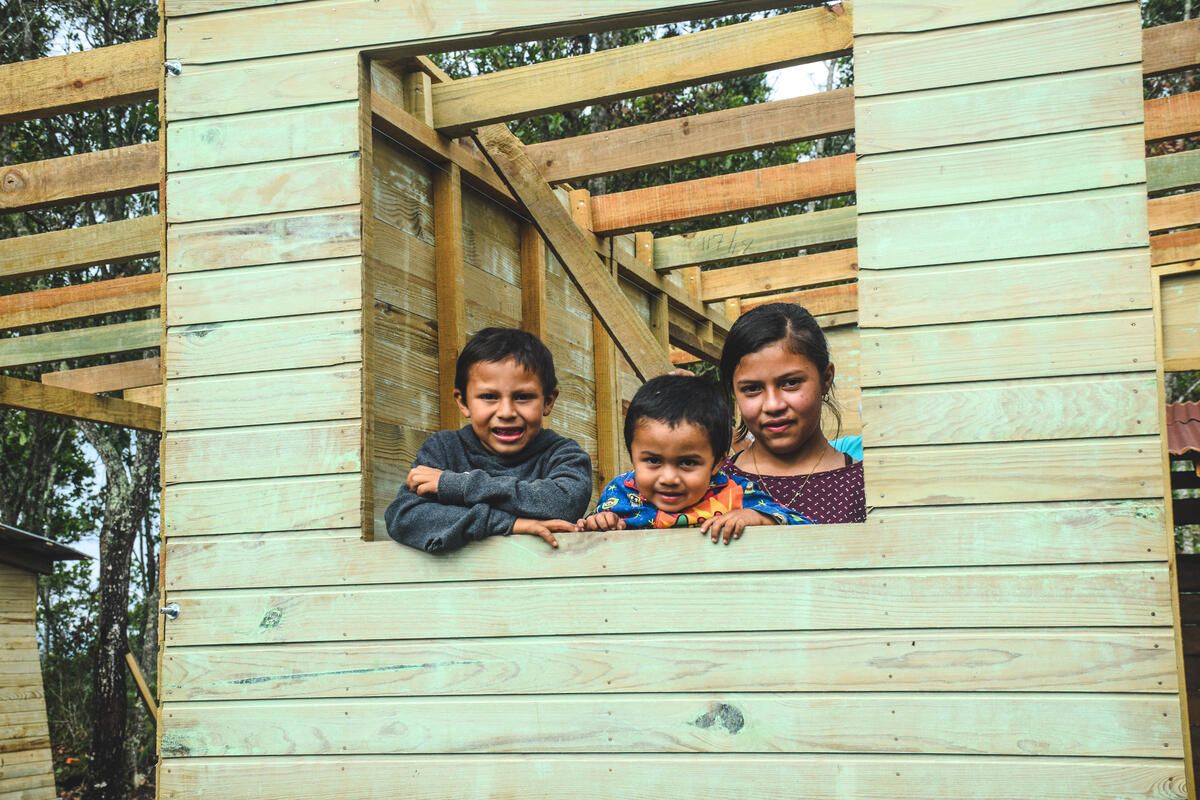 Elquin and his siblings in the window of their new home in Honduras