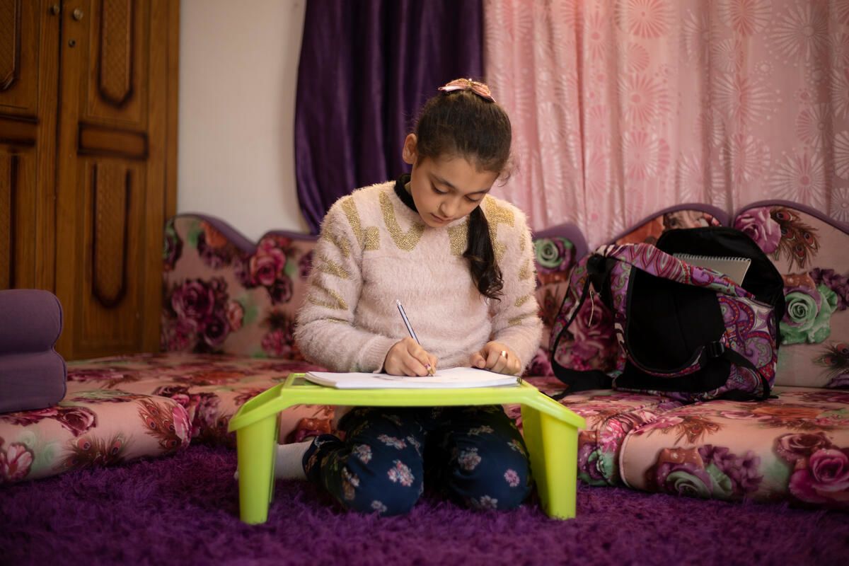 Syrian refugee child draws strong women in her home in refugee camp in Jordan while she dreams of a different future