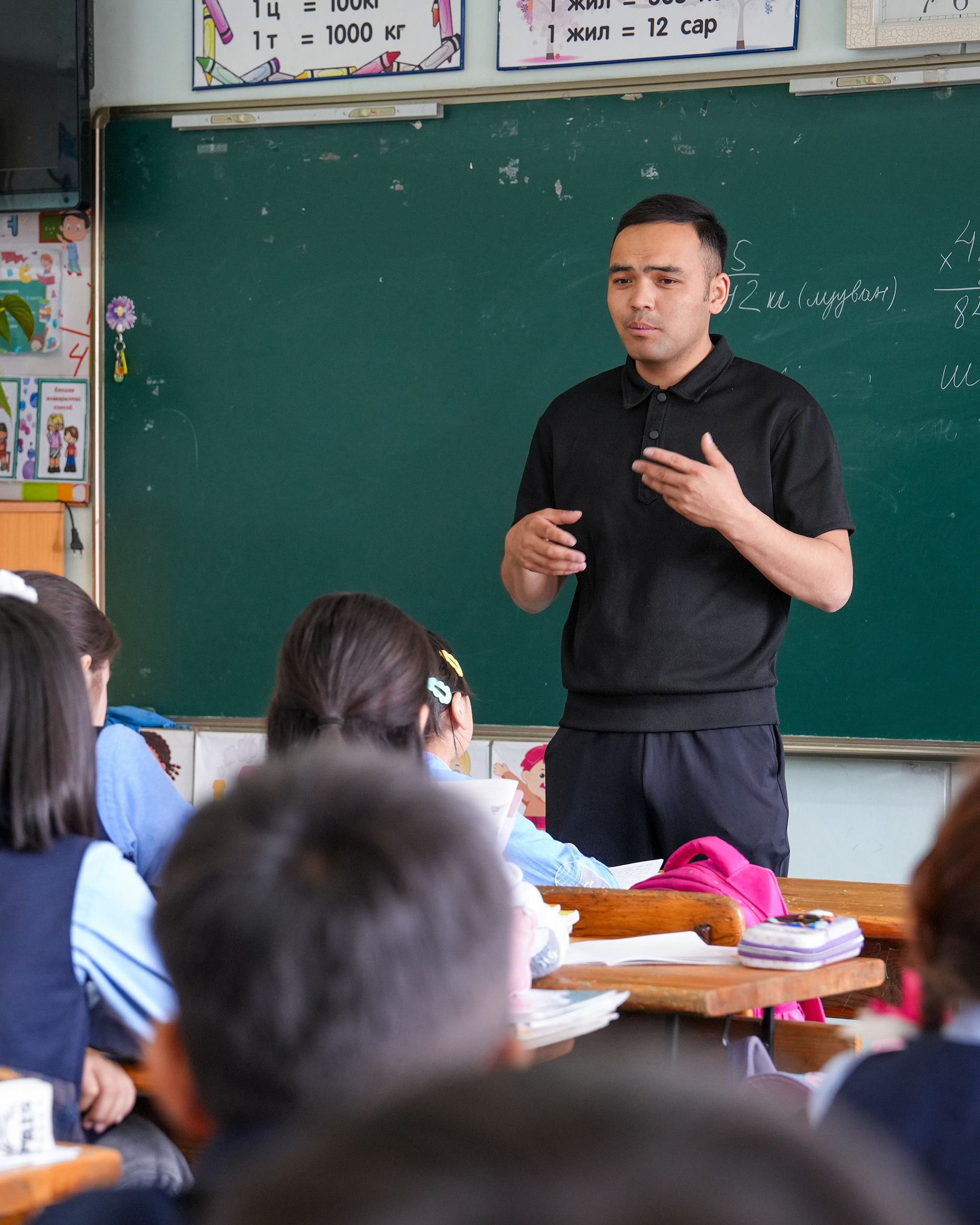 Bazar stands in front of a classroom of students